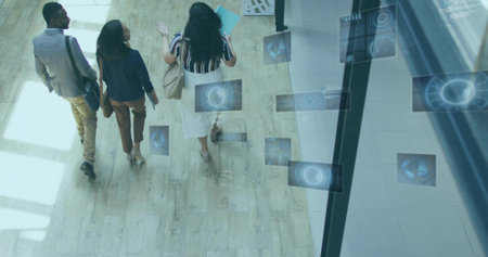 Walking trio in business attire carrying tote bag, folder and work bags in lobby, floating panels. Corporate, teamwork, innovation, modern, professional, digital, collaborationの写真素材