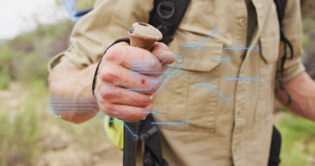 Hiker's hand gripping trekking pole on rocky hillside trail, with long-sleeve shirt and backpack....