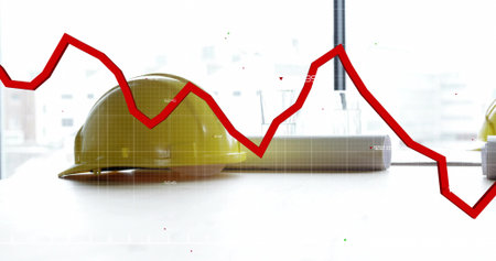 Resting yellow construction helmet on desk in office by large window, with red line graph overlay. Industrial, professionalism, minimalism, corporate, finance, business, analyticsの写真素材