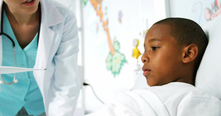 Pointing doctor wearing white lab coat beside hospital bed in clinic showing chart, copy space. Pediatric, healthcare, medical, child, doctor, clinical, therapyの写真素材