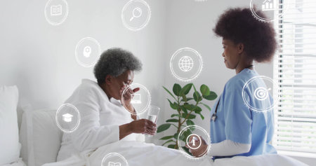 Patient in bathrobe drinking water from glass in care room, with nurse in scrubs stethoscope plant....