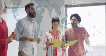 Standing group of four professionals discussing in office, with yellow folder and map overlay....