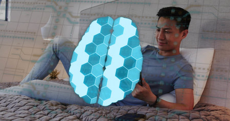 Man holding smartphone while reclining in bedroom, with knitted blanket, brain overlay, copy space....