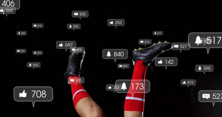 Showing legs in red socks, black cleats in studio with floating notification icons showing counters. Athletics, sportswear, digital interface, performance, high-energy, modern, technologyの写真素材