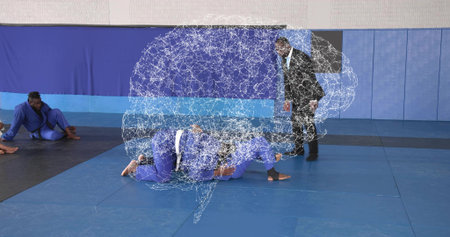 Grappling fighters in blue uniforms controlling opponent on back in gymnasium. Martialarts,...