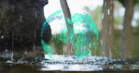 Hovering holographic green wireframe sphere above wet forest floor puddle, with falling raindrops....