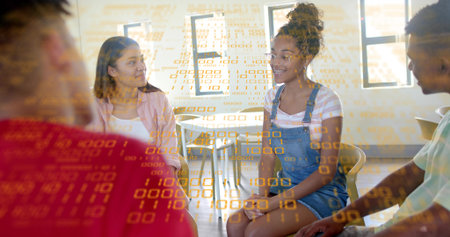 Collaborating group with woman wearing overalls sharing code in classroom, notebook binary overlay....
