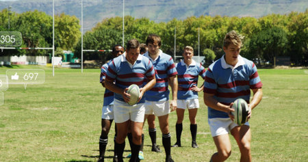 Rugby players walking on grass pitch in striped jerseys with rugby balls and goalposts. Athleticism, teamwork, sportsmanship, outdoor, competition, active, dynamicの写真素材