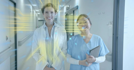 Standing nurse in scrubs and lab coat doctor using tablet in hospital corridor, with digital beams. Medical, healthcare, technology, futuristic, clinical, innovation, professionalismの写真素材
