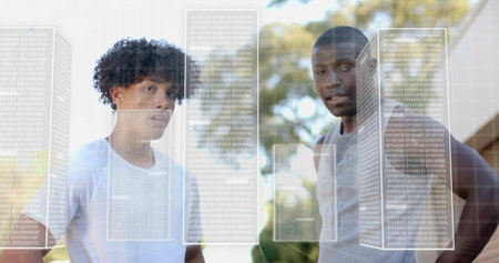 Standing two men wearing white, grey tees observing by trees and building, showing binary overlays....