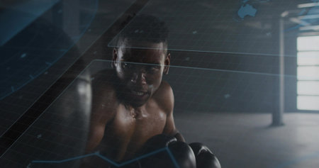 Standing shirtless boxer analyzing holographic grid interface at boxing gym, with gloves and shorts. Athletic, training, technology, fitness, strength, professionalism, modernの写真素材