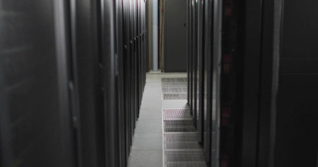 Central aisle running between server racks in data center hallway with tiles and cable conduits....
