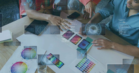 Three designers in floral blouse and plaid shirt reviewing UI mockups in studio, with smartphones. Collaboration, innovation, creativity, brainstorming, technology, workspace, teamworkの写真素材