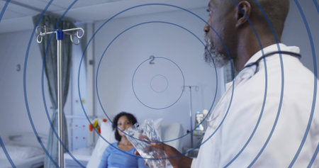 Senior doctor with stethoscope holding IV bag beside IV pole in ward, copy space. Medical, healthcare, professional, clinical, caregiver, wellness, diagnosticの写真素材