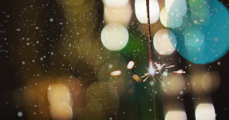 Image of snow falling over sparkler. Christmas, celebration and digital interface concept digitally generated image.の写真素材
