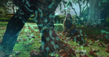 Picking couple collecting fallen leaves in public park, with green circuit board overlay. Outdoor,...