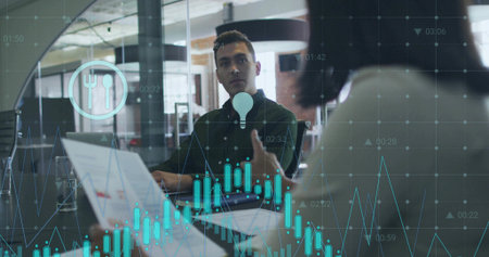 Mid adult male professional listening to colleague in meeting room, with open laptop, data overlays. Collaboration, analytics, teamwork, modernity, innovation, corporate, digitalの写真素材