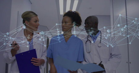 Walking team in lab coats discussing files in hospital corridor with smartphone under overlay....