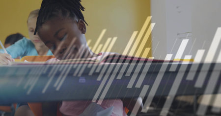 Writing girl wearing pink t-shirt leaning over desk at school, with pencils, papers and whiteboard. Kids, education, learning, classroom, stationery, concentration, teamworkの写真素材