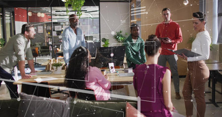 Collaborating team of coworkers discussing strategy in open-plan office, with monitor and greenery. Cooperation, brainstorming, workspace, productivity, modern, environment, teamworkの写真素材