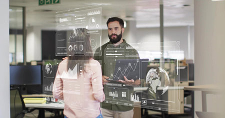 Two colleagues analyzing rotating charts in open office, with monitors and casual attire. Business, teamwork, data visualization, collaboration, corporate, modern, analyticsの写真素材