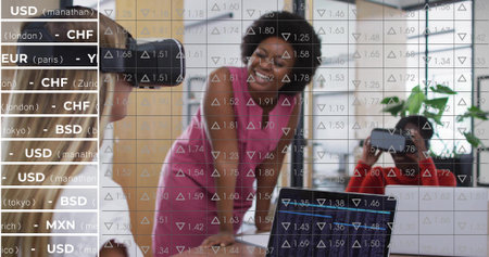 Smiling businesswoman leaning on modern office table, with colleagues using laptop and VR headset. Professional, teamwork, collaboration, innovation, technology, corporate, modernの写真素材