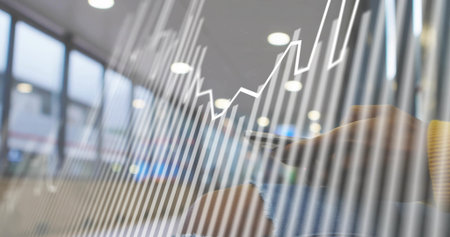 Businesswoman in yellow top, blue jeans tapping smartphone, analyzing charts in office, copy space. Professional, analytics, modern, corporate, urban, innovation, digitalの写真素材