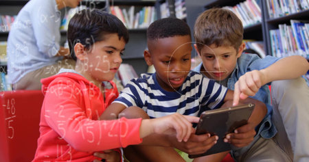 Sitting three boys pointing at tablet on red bench in library area, surrounded by bookshelves. Children, education, learning, literacy, collaboration, technology, diversityの写真素材