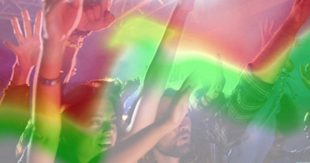 Five concertgoers raising arms and dancing under steel truss at venue, with haze and wristbands. Livestream, rave, energetic, vibrant, nightlife, festival, celebrationの写真素材