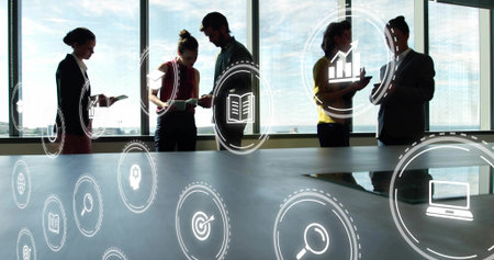 Suited professionals collaborating at conference table with documents, mobile devices and icons. Corporate, teamwork, modern, technology, networking, strategy, communicationの写真素材