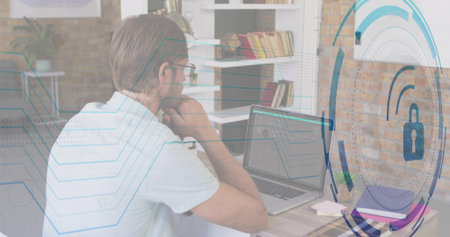 Studying IT professional resting chin at home office, with laptop coffee mug and security graphics. Technology, cybersecurity, modern, workspace, innovation, productivity, digitalの写真素材