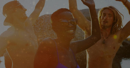 Celebrating friends raising arms on rocky shore at sunset, wearing sunglasses and pendant necklace. Adventure, camaraderie, outdoor, vibrant, relaxing, leisure, sunsetの写真素材
