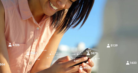 Smiling Hispanic woman tapping smartphone on rooftop, with follower count overlays, copy space. Social networking, technology, urban, vibrant, modern, connectivity, communicationの写真素材