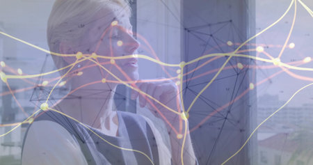 Gazing senior executive resting chin on hand by office window, with network visualization overlay. Professional, contemplative, modern, technology, corporate, skyline, inspirationの写真素材