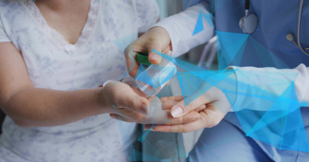 Doctor in scrubs dispensing pills into patient palm in exam room, with stethoscope and pill bottle. Healthcare, medical, pharmaceuticals, treatment, wellness, clinical, professionalismの写真素材