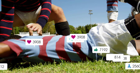 Lying rugby player in striped jersey and white shorts on grassy field, with social media icons. Athletic, teamwork, competitive, sport, outdoor, vibrant, activewearの写真素材