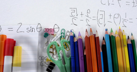 Displaying stationery on study desk with colored pencils, scissors, clips, pins and math scribbles. Art supplies, education, creativity, colorful, organization, learning tools, designの写真素材