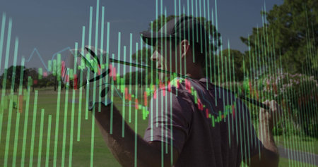 Swinging golfer gripping club on fairway, wearing maroon shirt golf glove. Outdoor, professional, leisureの写真素材