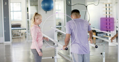 Practicing patient in purple tee and therapist in pink top walking between parallel bars at rehab....