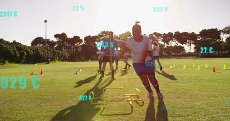 Sprinting female soccer player performing hurdle drill at golden hour grass pitch, with cones. Athletes, teamwork, training, fitness, outdoor, vibrant, dynamicの写真素材