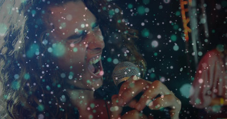 Singing lead vocalist performing on concert stage, with microphone under colored lights. Music, performance, concert, stage, nightlife, entertainment, crowdの写真素材