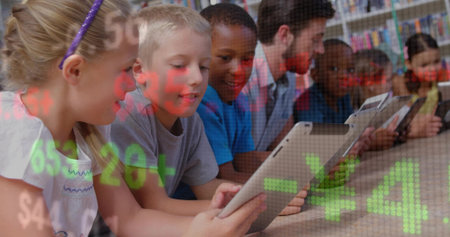 Assisting teacher in blazer guiding children using tablets at library table with bookshelves. Education, technology, classroom, learning, literacy, innovation, collaborationの写真素材