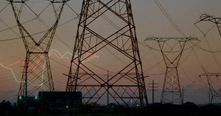 Towering lattice steel pylons, power lines stretching across utility site at dawn, with substation....
