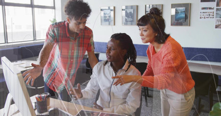 Collaborating three coworkers wearing business casual attire at desktop computer in modern office....
