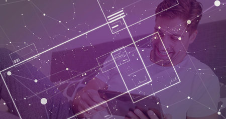 Navigating purple tinted interface, mid adult male using tablet sitting on sofa at home, copy space. Technology, innovation, modern, connectivity, digital, casual, homeの写真素材