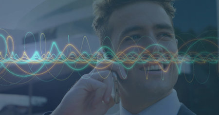 Smiling executive in suit answering smartphone call outside office, waveform overlays, copy space. Technology, communication, professional, urban, digital, infrastructure, innovationの写真素材