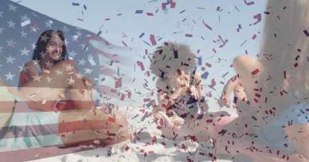 Relaxing friends wearing swimwear and straw sun hat chatting on beach towel at shore, with confetti. Vacation, celebration, leisure, lifestyle, vibrant, outdoor, camaraderieの写真素材