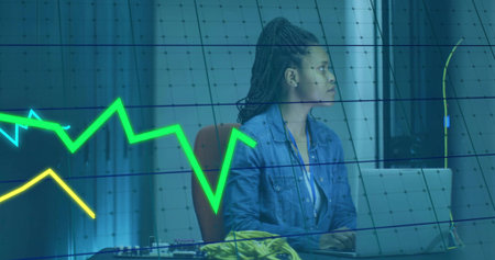 Engineer in denim jacket analyzing data overlay in lab, with laptop, network cables, circuit boards. Technology, digital, innovation, engineering, electronics, network, dataの写真素材