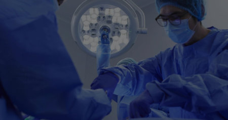 Performing surgery Asian surgeon handling forceps in surgical suite under LED lamp, copy space....