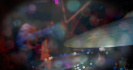 Shining drum cymbal catching lights on live stage, with drum kit, microphone stand, copy space. Musician, performance, lighting, vibrant, rhythm, venue, stagecraftの写真素材